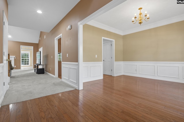 unfurnished room with ornamental molding, light wood-type flooring, and a chandelier