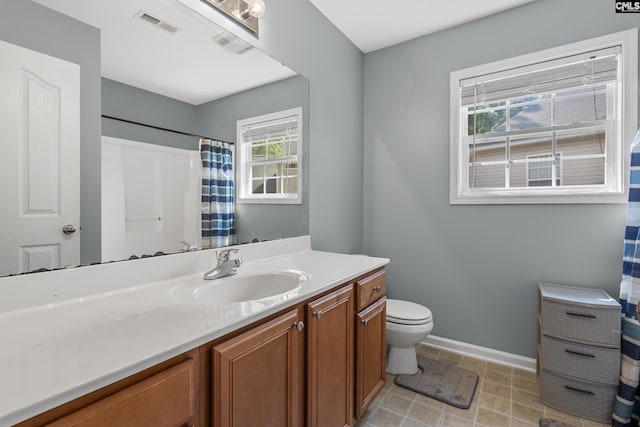 bathroom featuring toilet, a healthy amount of sunlight, and vanity