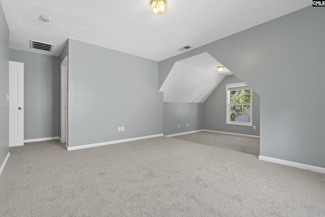 additional living space with light carpet and vaulted ceiling