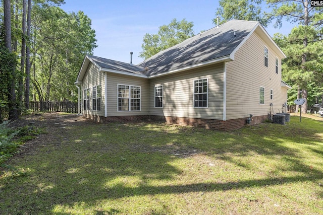 back of property with cooling unit and a yard