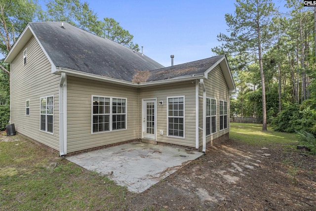 back of property featuring a lawn, central air condition unit, and a patio area