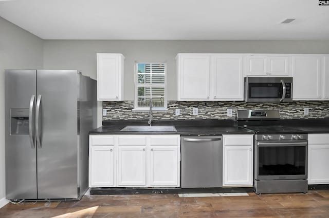 817 Wickham Ln, Columbia, SC 29229 - kitchen with white cabinets, a sink, dark countertops, and appliances with stainless steel finishes