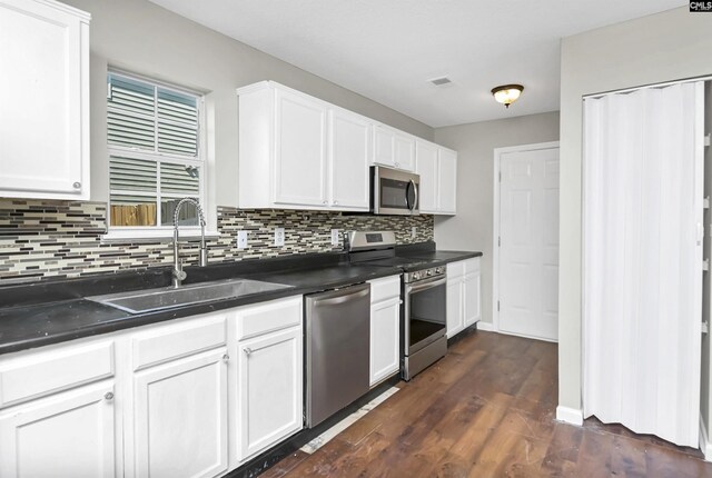 817 Wickham Ln, Columbia, SC 29229 - kitchen with white cabinetry, stainless steel appliances, a sink, dark countertops, and visible vents