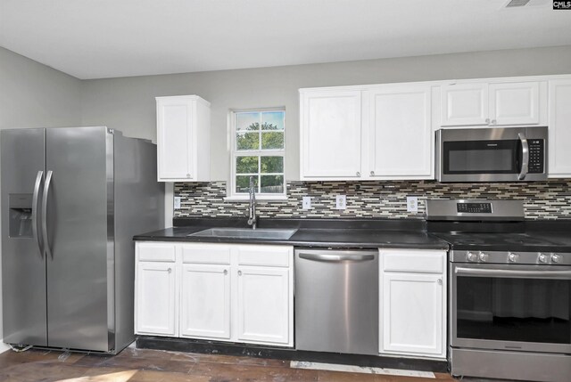 817 Wickham Ln, Columbia, SC 29229 - kitchen with a sink, dark countertops, white cabinets, and appliances with stainless steel finishes