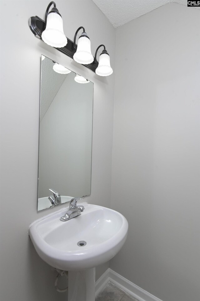 817 Wickham Ln, Columbia, SC 29229 - bathroom with baseboards, a sink, and a textured ceiling