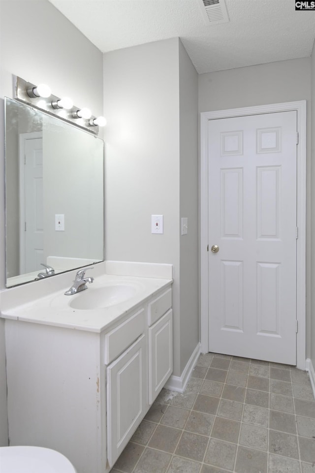 817 Wickham Ln, Columbia, SC 29229 - bathroom featuring a textured ceiling, visible vents, baseboards, toilet, and vanity