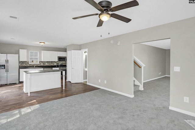 817 Wickham Ln, Columbia, SC 29229 - kitchen with white cabinetry, tasteful backsplash, open floor plan, stainless steel appliances, and dark carpet