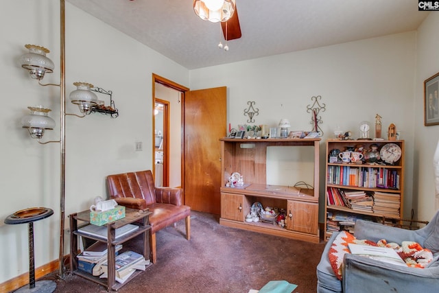 living area featuring dark carpet and ceiling fan