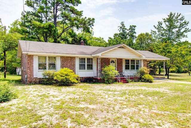 ranch-style home featuring a porch and a front yard