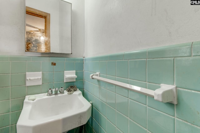 bathroom featuring tile walls and sink