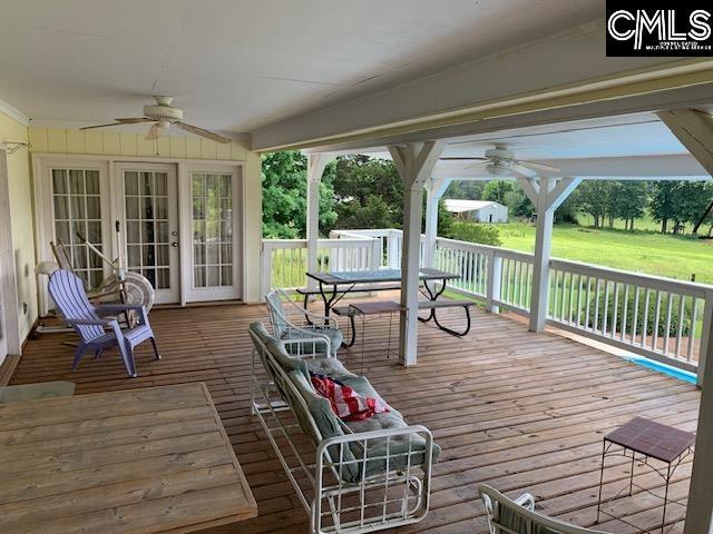 wooden deck featuring ceiling fan and a lawn