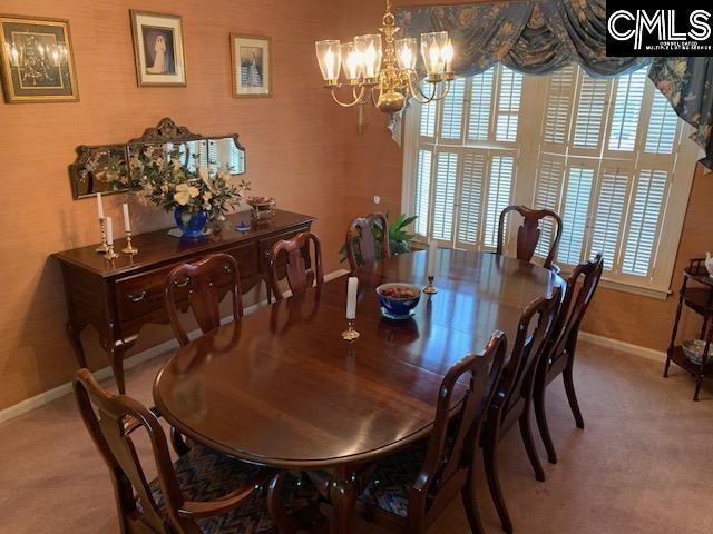 dining room with carpet and a chandelier