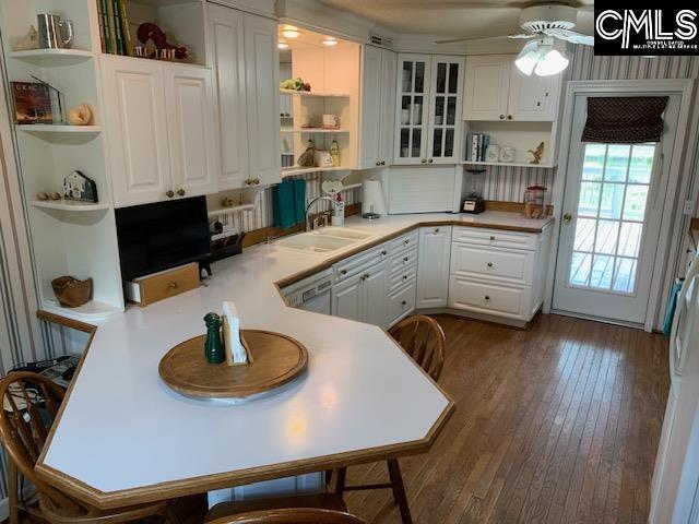 kitchen featuring sink, white cabinetry, dishwasher, dark wood-type flooring, and kitchen peninsula