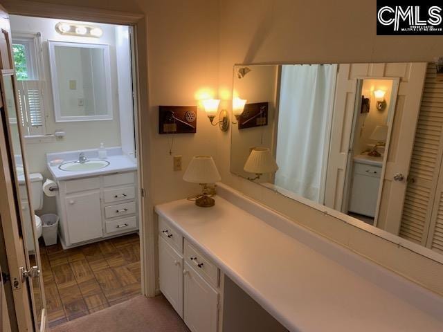 bathroom featuring parquet flooring and vanity