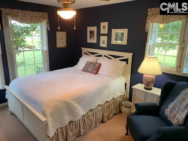 bedroom with radiator heating unit and light colored carpet