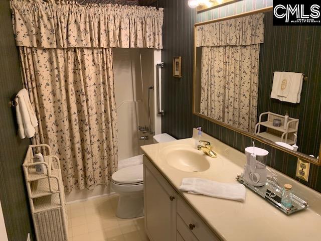 bathroom with toilet, vanity, and a shower with curtain