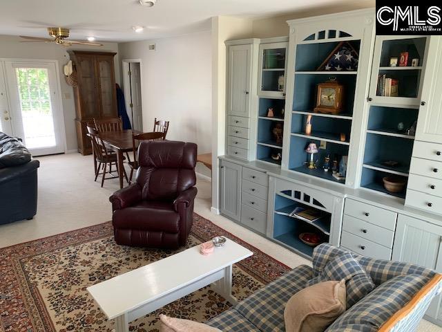 living room featuring ceiling fan and light colored carpet