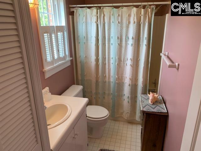 bathroom featuring toilet, vanity, and walk in shower