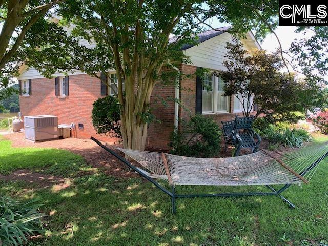 view of property exterior with central AC and a lawn