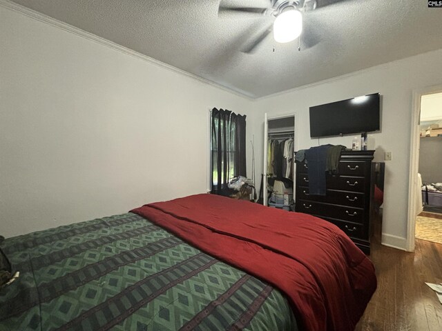 bedroom featuring dark hardwood / wood-style floors, cooling unit, ornamental molding, and ceiling fan