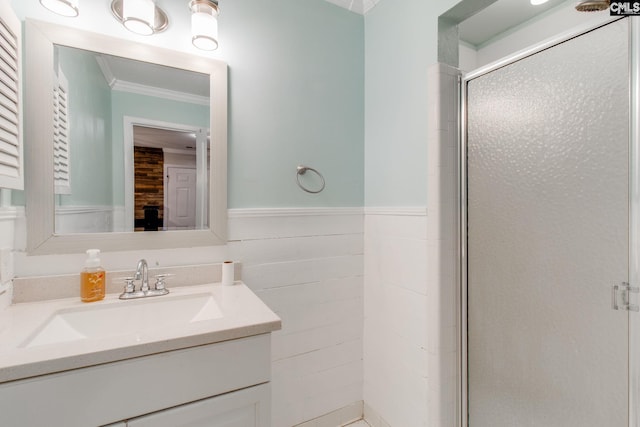 bathroom featuring a shower with shower door, vanity, and crown molding