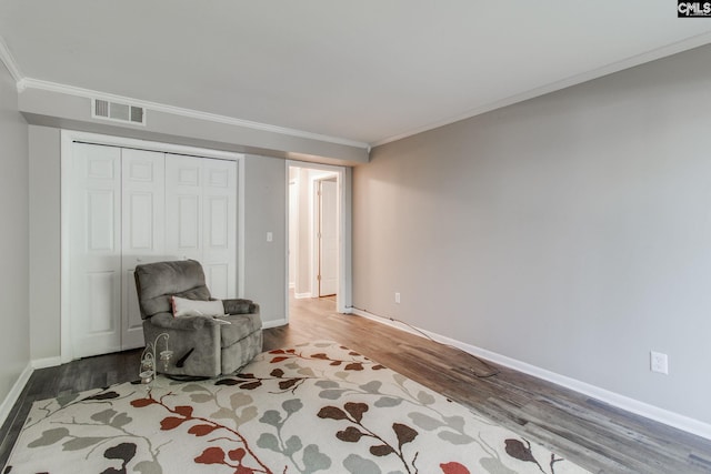 sitting room featuring light wood-type flooring and ornamental molding