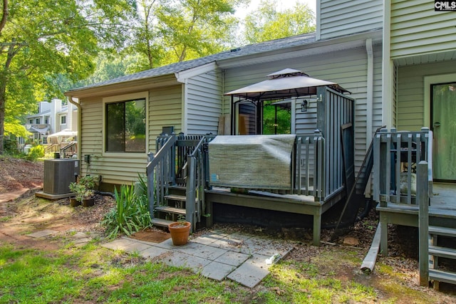 back of property featuring central AC unit and a gazebo