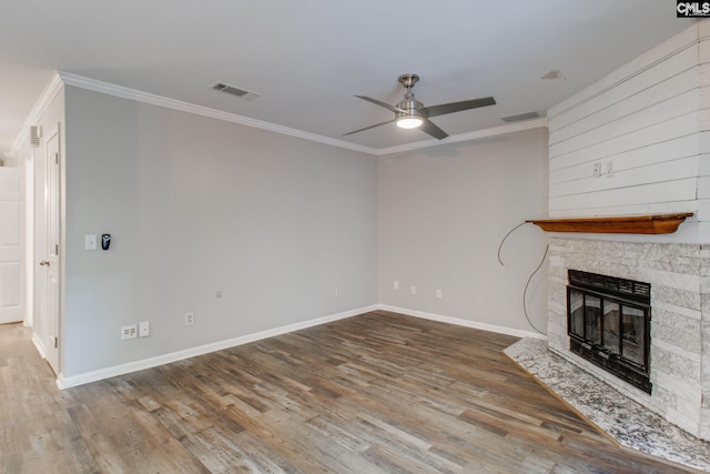 unfurnished living room featuring ceiling fan, hardwood / wood-style floors, crown molding, and a fireplace