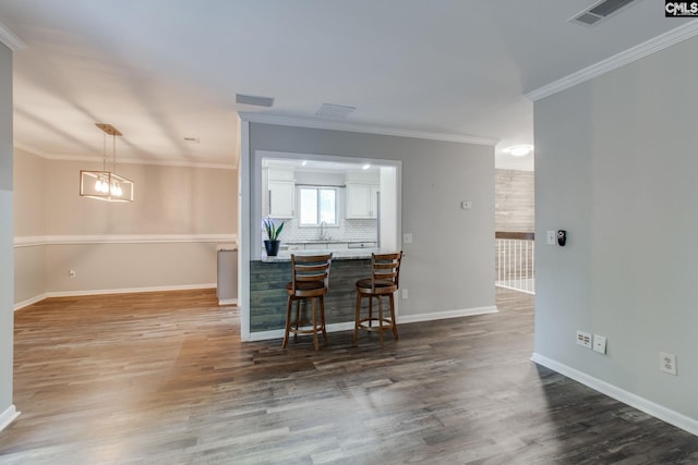 kitchen with dark hardwood / wood-style flooring, decorative backsplash, pendant lighting, and a breakfast bar