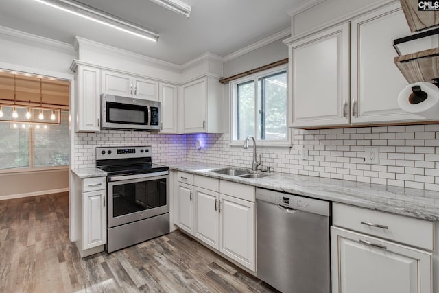 kitchen with stainless steel appliances, light hardwood / wood-style floors, white cabinetry, and sink