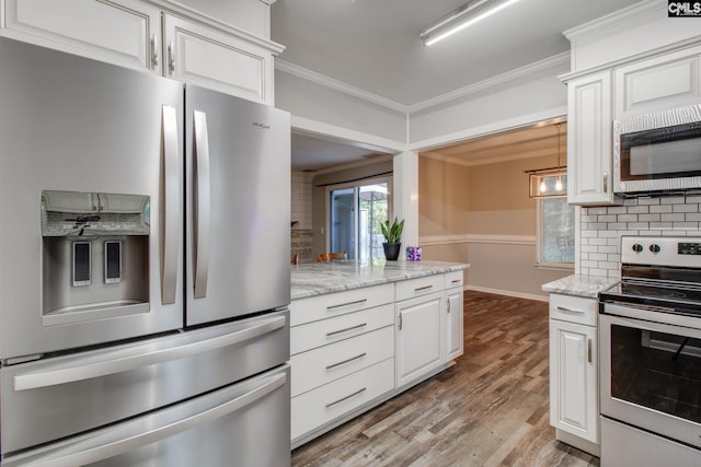 kitchen featuring light stone countertops, white cabinets, appliances with stainless steel finishes, and tasteful backsplash