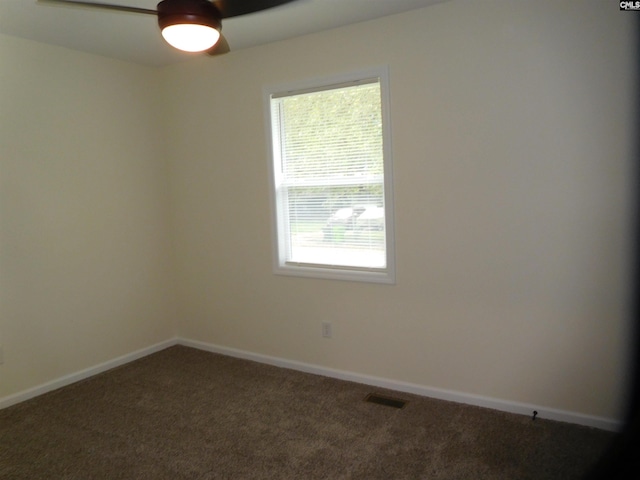 spare room with dark carpet