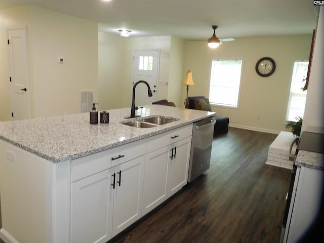 kitchen featuring sink, light stone counters, stainless steel dishwasher, a wealth of natural light, and white cabinets