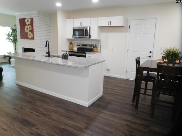 kitchen featuring sink, appliances with stainless steel finishes, light stone counters, white cabinets, and dark hardwood / wood-style flooring