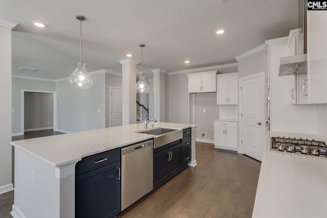 kitchen featuring hanging light fixtures, white cabinets, sink, stainless steel appliances, and a center island with sink