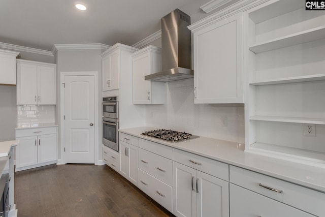 kitchen with crown molding, appliances with stainless steel finishes, backsplash, white cabinets, and wall chimney range hood