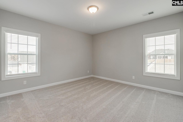 unfurnished room featuring light carpet