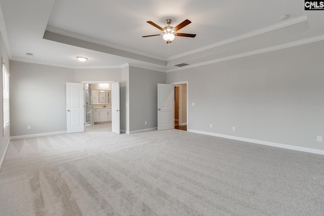 carpeted empty room featuring crown molding, ceiling fan, and a tray ceiling