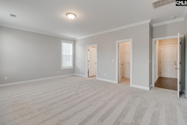 unfurnished bedroom with a spacious closet, a closet, ornamental molding, light colored carpet, and ensuite bathroom