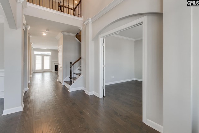 foyer with ornamental molding and dark wood-type flooring