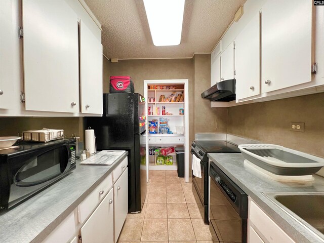 kitchen with light tile patterned flooring, a textured ceiling, white cabinets, black appliances, and sink