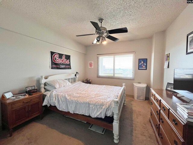 carpeted bedroom featuring a textured ceiling and ceiling fan