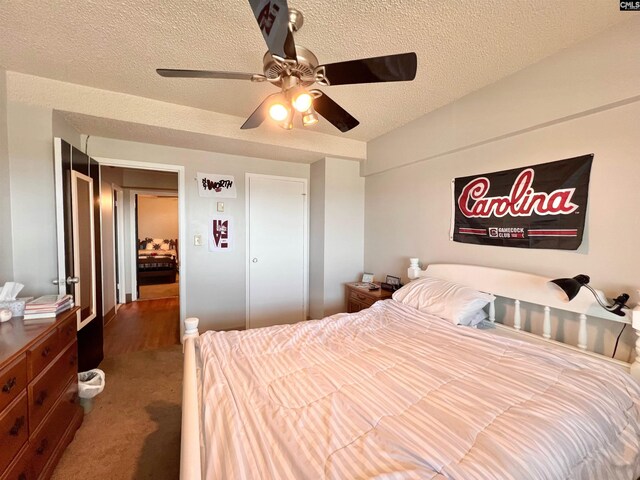 carpeted bedroom featuring a textured ceiling and ceiling fan