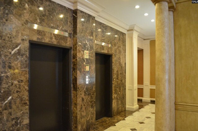 interior space with tile patterned floors, decorative columns, elevator, and ornamental molding