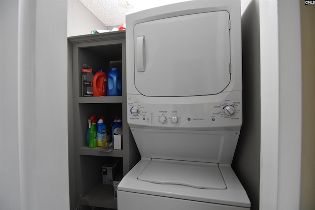 laundry room with built in shelves, a textured ceiling, and stacked washer / dryer