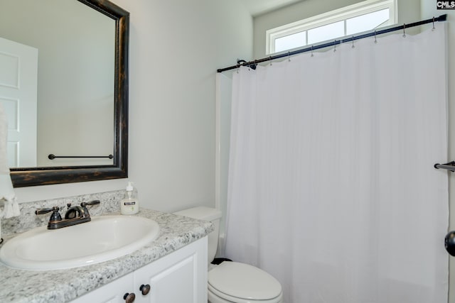 bathroom featuring vanity, curtained shower, and toilet