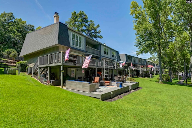 back of house featuring a yard, a wooden deck, a patio, and outdoor lounge area