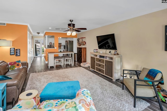 living room featuring dark hardwood / wood-style floors, crown molding, and ceiling fan