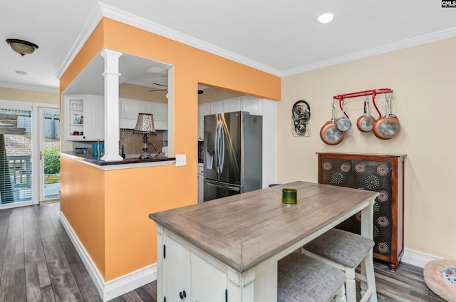 kitchen featuring white cabinetry, ornamental molding, dark hardwood / wood-style floors, stainless steel fridge, and backsplash