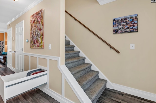 stairs featuring ornamental molding and dark hardwood / wood-style floors